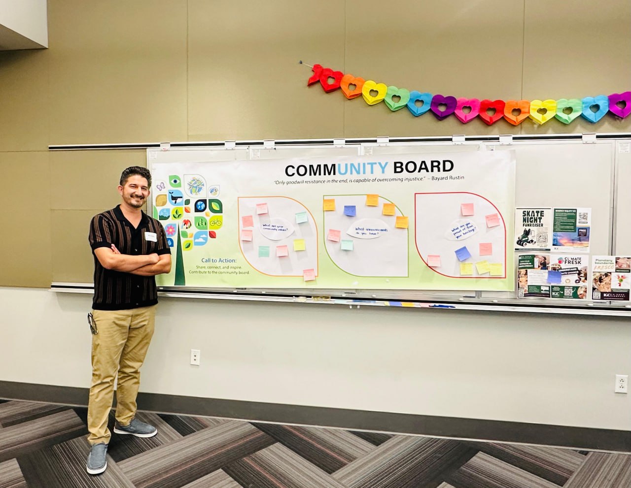 Mustafa Sharifi standing in front of a community board with the Environmental Justice Working Group, San Diego